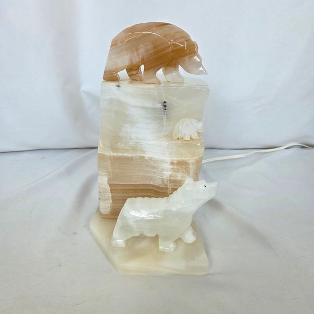 A substantial vintage Mexican carved-stone accent lamp depicting three polar bears climbing across a glowing iceberg,...