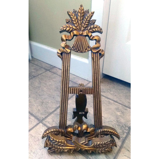 This hand-carved picture easel has a Mexican or Country design to it. It is made from thick wood that is painted gold. The...