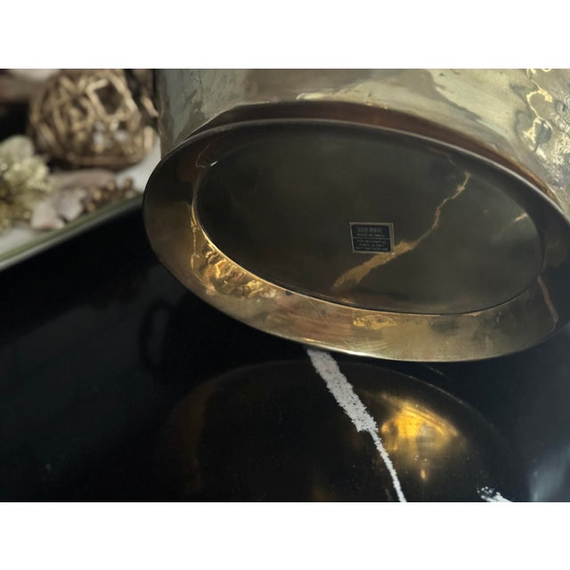 Solid, heavy brass with hand-forged handles, domed rivets, and a warm natural patina. Sculptural rim and artisan-made...