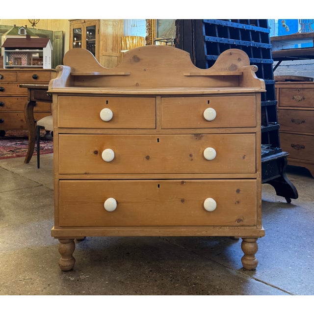 Charming pine washstand, circa 1860. Scrolled detailing frames the top, where a scalloped backsplash holds two small...