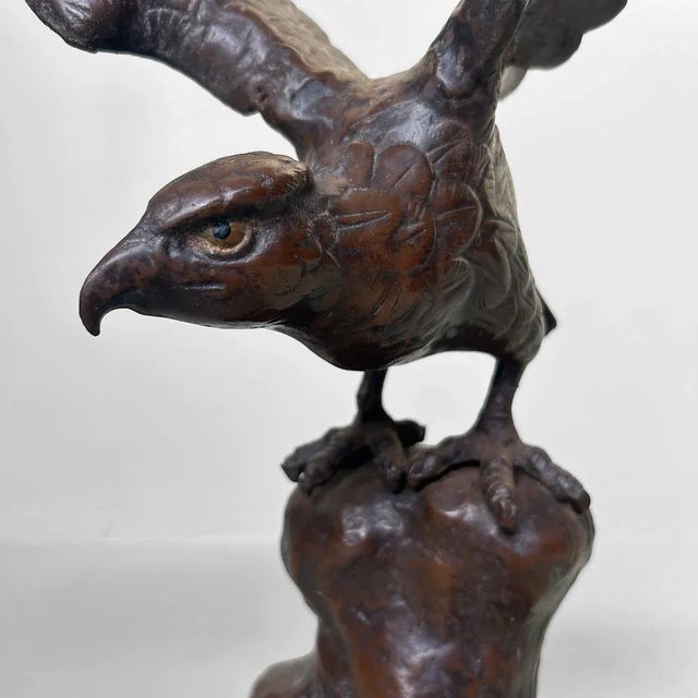 This Japanese cast-iron sculpture depicts a powerful eagle poised to take flight. with its wings spread wide and a...
