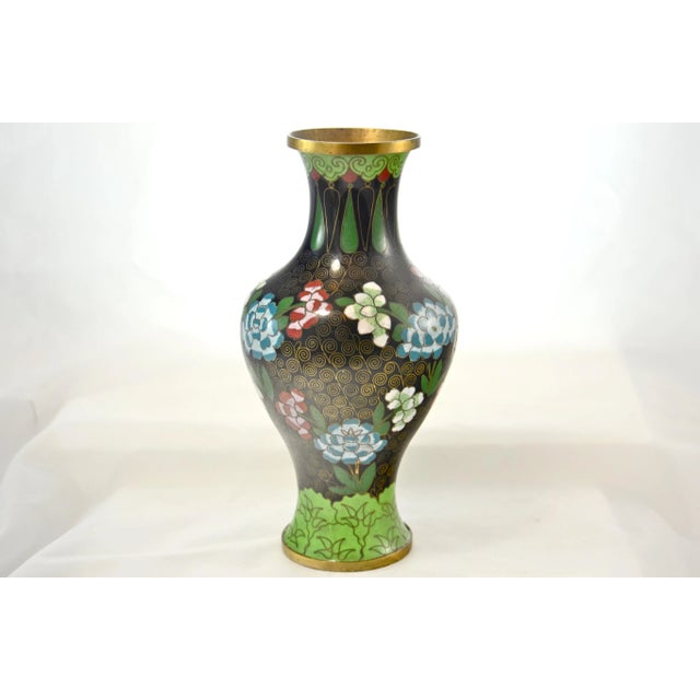 Tall intricate cloisonne vase with large aqua, magenta and green flowers accented by tight gold encrusted spirals over a...