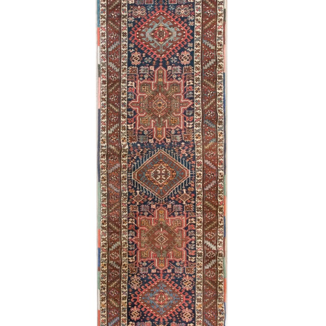 A gorgeous early 20th century Persian Heriz runner with multiple stylized floral medallions living in a densely woven...