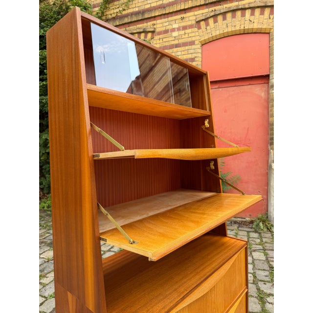This cabinet with drop-down compartments and a display case from VEB Möbelindustrie Halle is an excellent example of...