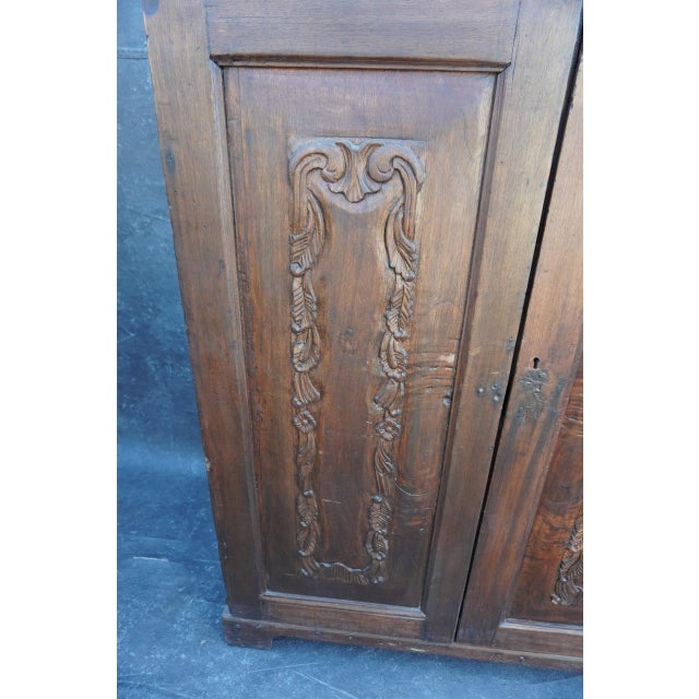 18th century Spanish Colonial walnut cabinet featuring a large two-door form with richly hand-carved panel details and an...