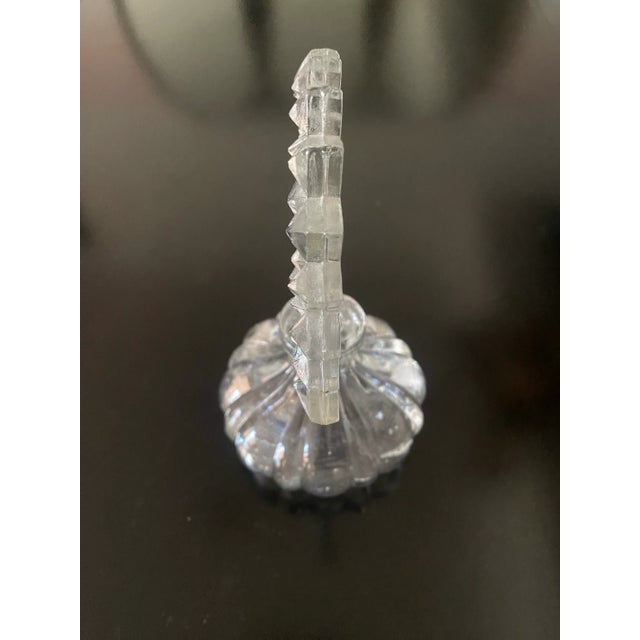A vintage Art Deco glass perfume bottle from the 1940s. Fan with starburst shaped stopper and round base.