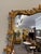 Striking 19th-century French gilded mirror, circa 1890, featuring an ornately hand-carved wood frame with an elegant oak...