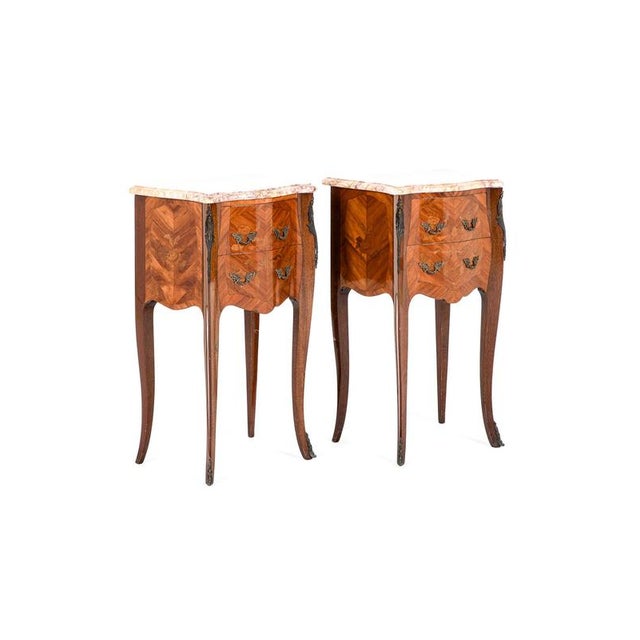 A charming pair of louis xv bedside cabinets of fine standing with inlaid kingwood marquetry. The cabinets display...
