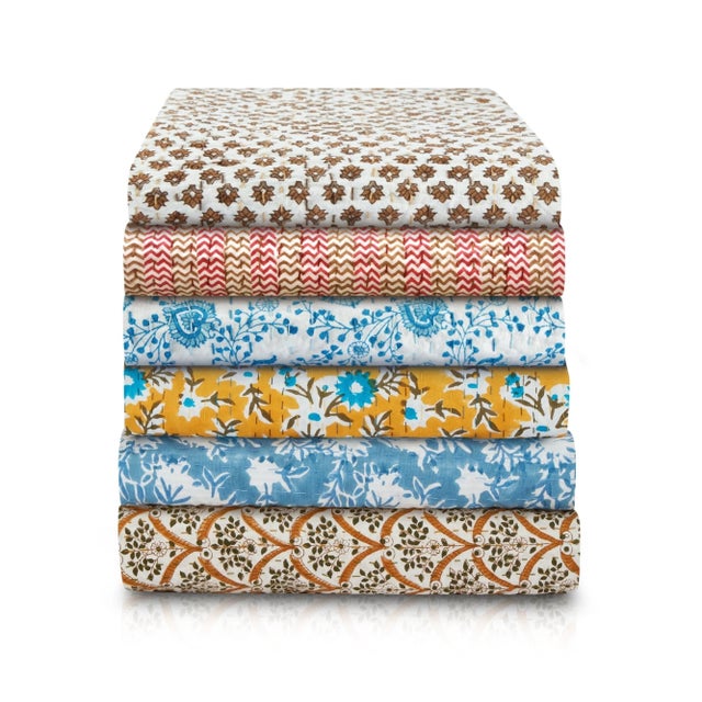 A soft, hand blocked reversible throw with coordinating stitching, one side with a geometric repeat, the other with a...