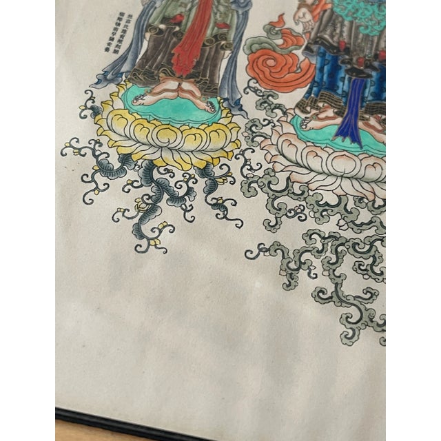 olorful Chinese Buddhist Bodhisattva painting of Guanyin depicted standing on a lotus blossom with two attendants. Ink and...