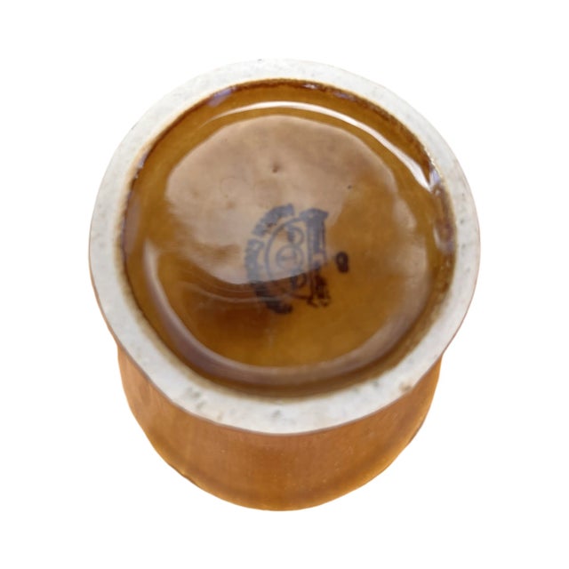 A vase with an unconventional retro design. The surface of the vase is glossy glazed in shades of brown and beige....