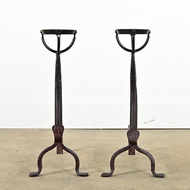 A slender pair of French 18th century wrought and forged iron fireplace andirons. They are Gothic-Mediterranean in style...
