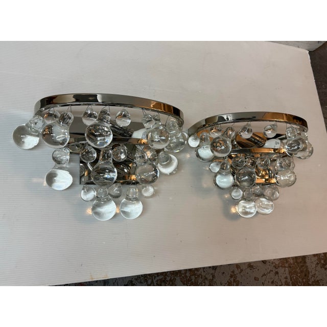 Design Plus Gallery presents a Pair of Bling Wall Sconces from Robert Abbey. Polished metal frames are draped with an...