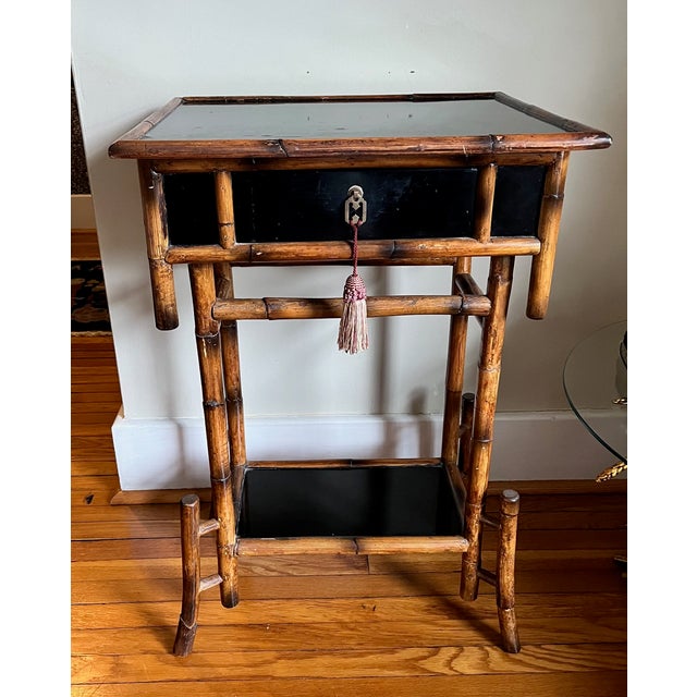 Japonisme Aesthetic Movement side table with bamboo frame and black lacquer wood. One drawer and tassel added to hardware....