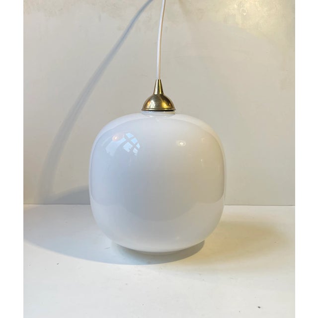 This large opaline glass pendant lamp surely has a shade that resembles Vilhelm Lauritzen's Radiohus VL 45. But it is...