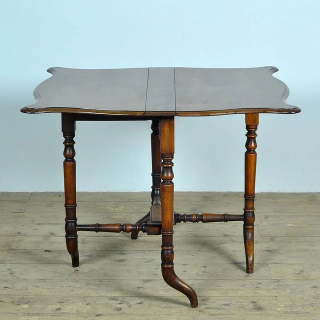 An English 19th century drop leaf table with folding top and beautiful turned legs. This English folding table, from the...