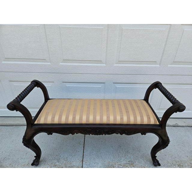 This striped beige two seat bench has a carved apron and legs, along with barley twist style side rails. The legs end in a...