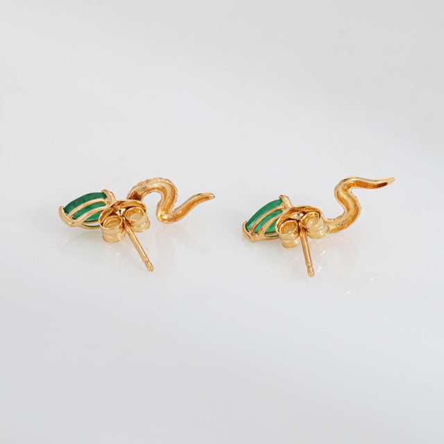 Finely detailed pair of vintage emerald snake earrings crafted in 18k yellow gold (circa 1990s). Pear cut emeralds measure...