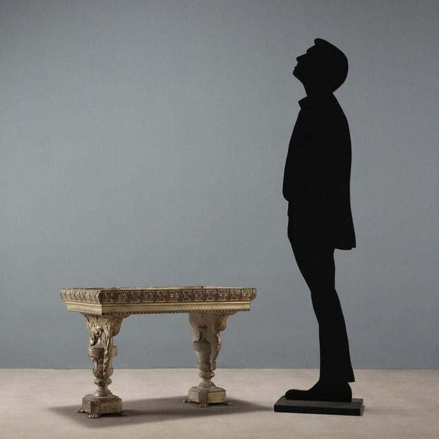 Display table. Glass top with velvet display compartment underneath, supported by a pair of antique carved and gilded...