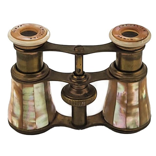 These antique opera glasses are branded as Chevalier Paris and feature a brass frame with inlaid mother-of-pearl detailing...