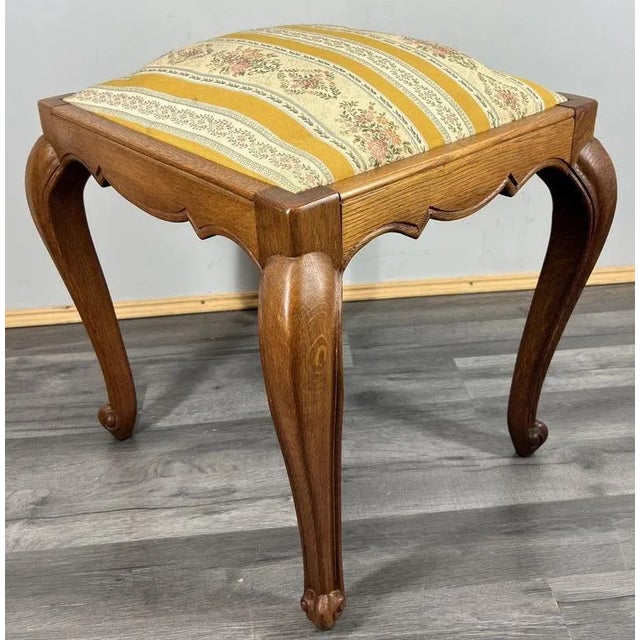 A beautifully proportioned Vintage French Louis style stool with elegant curves and a refined upholstered seat. The piece...