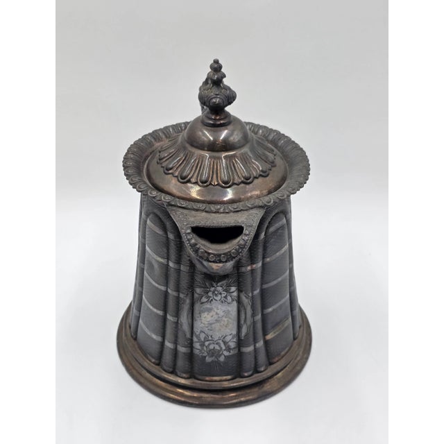 This Antique 19th C Meriden Water Pitcher Decanter is a bold and ornate piece made of silver plate, featuring a Victorian...