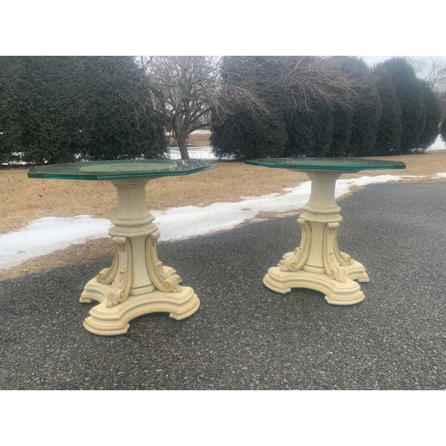 Matched pair of glass topped end tables. Carved gilt wood bases, white washed finish with gold accent. Hexagon cut glass...