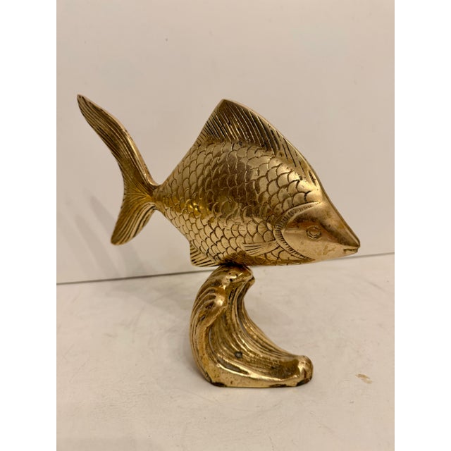 Brass Tropical Tang Fish Sculpture on a wave-cast stand. Features felt on the bottom of the base with a "Made In Korea"...