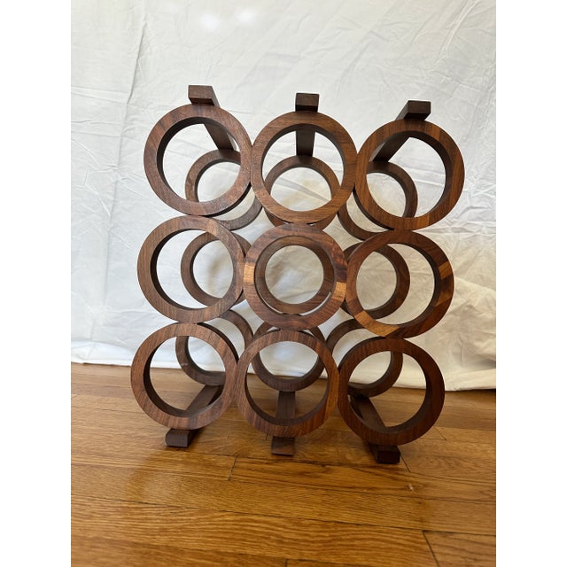 Sleek mid-century walnut wine rack by Kustom Kraft, circa 1960s. Features a sculptural nine-bottle configuration of...