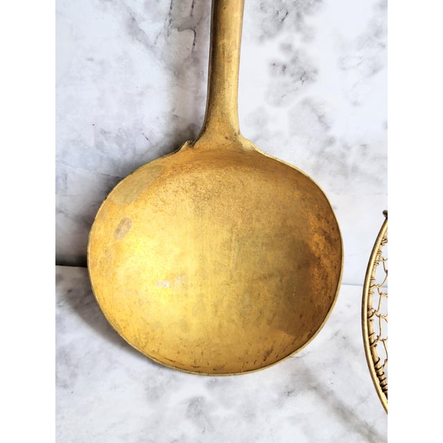 This is an antique solid brass fireplace ladle and the strainer has a bamboo handle. The hand-crafted brass ladle is...