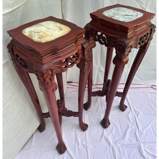 pair of solid rosewood display stands. Richly grained reddish-brown hardwood frame with a hand-polished finish. The tops...