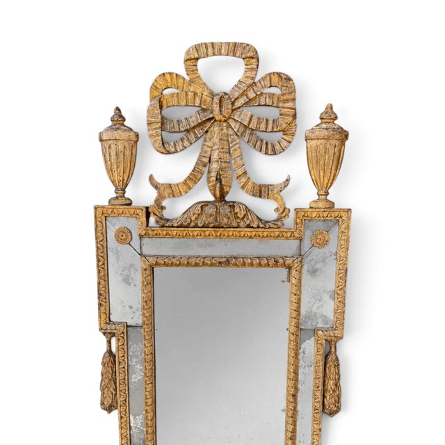A refined pair of late 18th-century Italian Neoclassical giltwood mirrors retaining their original mirror plates. Each...