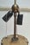A striking vintage floor lamp made in Italy, featuring an ornate sculptural column finished in antique gold with warm...