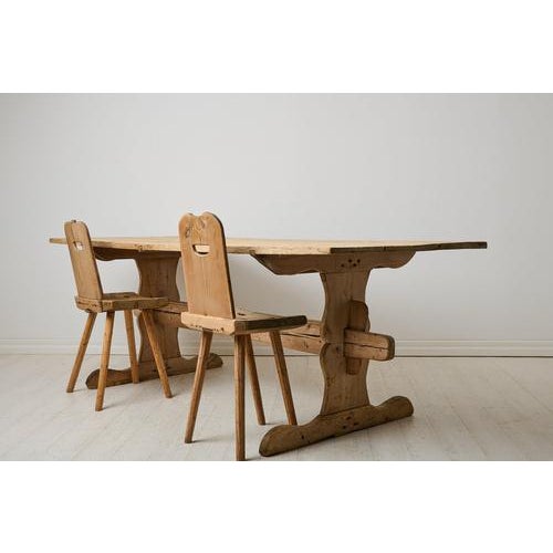 Antique Swedish dining table from the mid 1800s. This antique trestle table has a robust table top in solid pine resting...