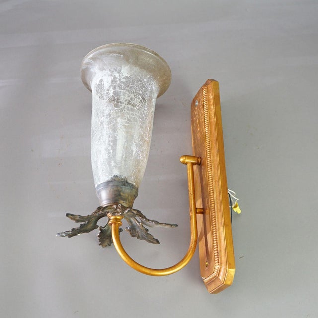 A pair of Mid-Century Modern French style Fleur-de-lis wall sconces with crackled glass shades, 20th century Measures -...