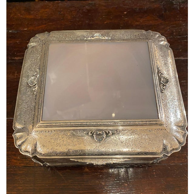 An elegant, molded sterling silver, hinged top box. The top features an onyx panel.