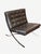 Iconic Barcelona chair by Ludwig Mies van der Rohe, featuring a sleek polished chrome X-frame base and deep tufted dark...