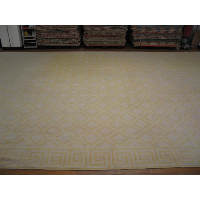 This light yellow gold color antique Indian flatweave geometric oversized cotton dhurrie rug is a striking example of...