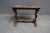 French Baroque style end table featuring an ornate hand-carved walnut base with scrolling acanthus details and trestle...