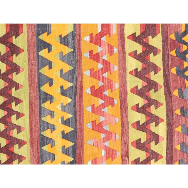 This vintage Turkish Kilim rug measures 2'9" x 9'6" and boasts traditional geometric patterns and bold colors. Hand-woven...