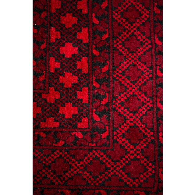Rug in dark red with elephant footprint motif. The main material is wool, as is the pile of the rug. The rug is hand-...
