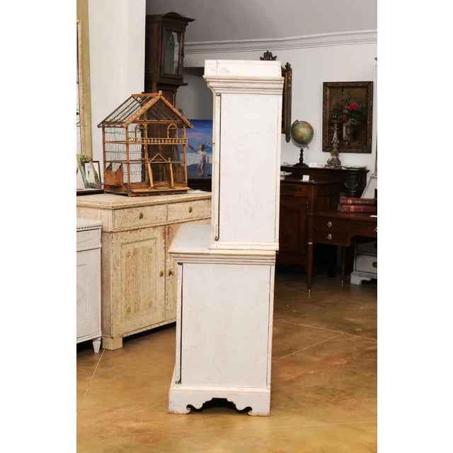 A Swedish Baroque period painted wood two-part cabinet from the mid 18th century, with angular pediment, four doors, inner...