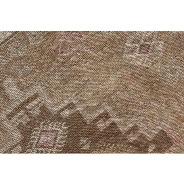 Measures: 4'10 x 12'0 This exquisite Vintage Turkish Kars gallery rug features a warm and inviting palette of browns,...