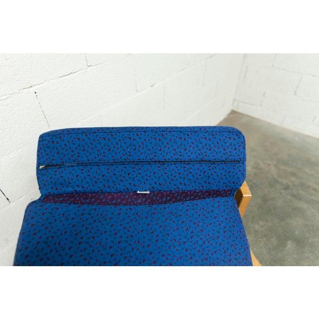 Comfortable 1980s blue and honey-colored pine fireside chair, comfortable foam seat with blue fabric and some purple...