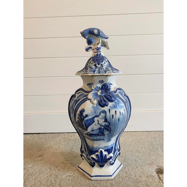 Blue and white Dutch Delft baluster form covered jar, 18th century, depicting a baby in the reeds within a scroll...