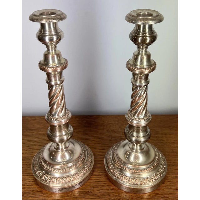 An elegant vintage French pair of silver-plated candlesticks , showcasing refined scrollwork, twisted stems and stepped...