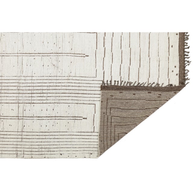 Elevate your space with this contemporary Moroccan-style wool rug, showcasing a minimalist aesthetic. Hand-knotted with...