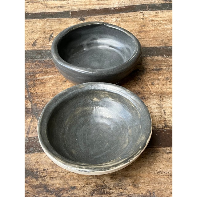 This set of two vintage studio pottery bowls epitomizes the minimalist elegance of mid-century hand-crafted ceramics. Each...