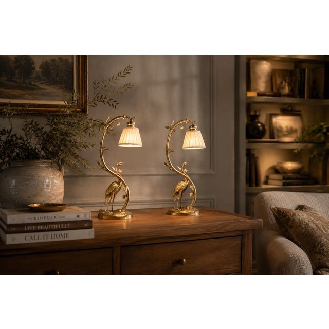 A rare and highly desirable matching pair of gilt bronze table lamps, each featuring a finely sculpted crane standing on a...