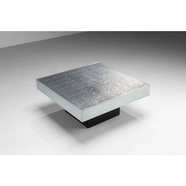 A striking vintage coffee table by Bernhard Rohne, distinguished by its sculptural form and richly decorated tabletop. The...
